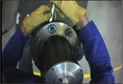Screenshot from a subcam film of a power plant operator centring a gasket
                            during the maintenance of a pump valve